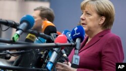 German Chancellor Angela Merkel speaks with the media as she arrives for an EU Summit in Brussels last month. Merkel's immigration policies have made her a target for the opposition in elections this year.