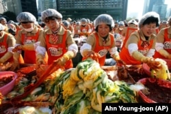 Para relawan membuat kimchi, sayuran tradisional untuk persiapan musim dingin di depan Balai Kota Seoul, Selasa, 16 November 2010. (Foto: AP/Ahn Young-joon)