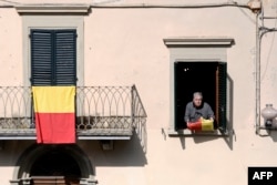A resident holds a flag bearing the colors of the Tuscan village of Vinci, where Leonardo Da Vinci was born, April 9, 2019 in Vinci. Locals are preparing to mark the 500th anniversary of the artist's death.