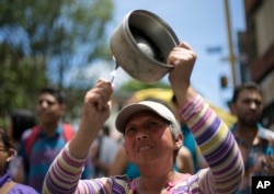 A woman bangs a pot to protest Venezuela's President Nicolas Maduro in Los Teques on the outskirts of Caracas, Venezuela, Sept. 7, 2016.
