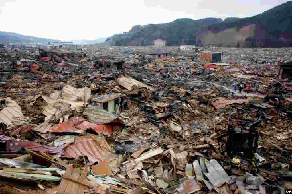 Residents walk past debris in Otsuchi March 15. 12,000 out of a population of 15,000 in the town have disappeared following Friday's massive earthquake and tsunami. (Reuters/Aly Song)