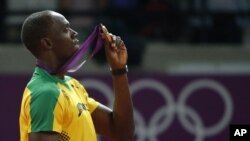 Jamaica's Usain Bolt holds up his gold medal for the men's 200-meter during the athletics in the Olympic Stadium at the 2012 Summer Olympics, London, August 9, 2012.