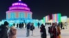 Visitantes toman fotografías cerca de esculturas de hielo en el Festival de Hielo y Nieve de Harbin en Harbin, provincia de Heilongjiang, China, 24 de diciembre de 2023. 