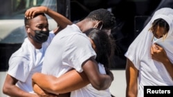 미국 텍사스주에서 본국으로 송환된 아이티인들이 21일 포르토프랭스 공항에 도착한 뒤 포옹하고 있다.