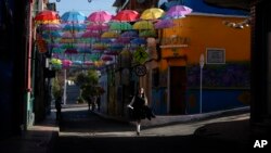 Una estudiante camina por la Calle de las Violetas de La Candelaria, en Bogotá, Colombia. El proceso para pacificar al pais sudamericano con varios frentes de conflicto se ha vuelto un camino escabroso. 