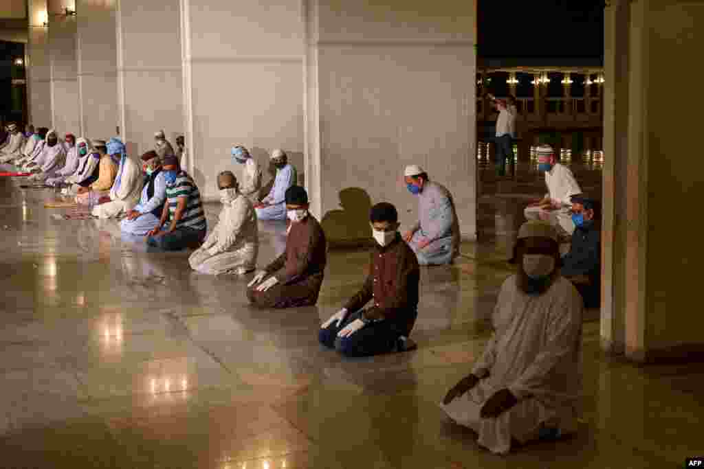 Jemaah pria Muslim menjaga jarak sosial (social distancing) pada saat salat Taraweh pada hari pertama bulan suci Ramadan di Masjid Agung Faisal di Islamabad, di tengah pandemi Covid-19 di Pakistan (24/4).