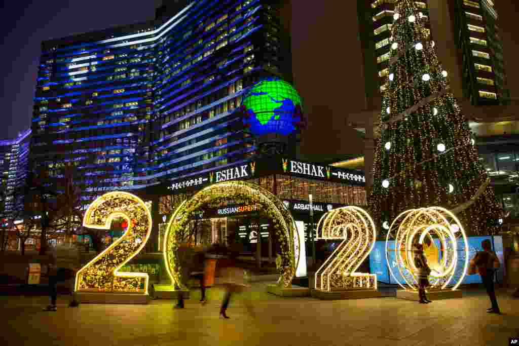 People walk in front of the upcoming new year decorated for Christmas and New Year celebrations along Novy Arbat Street in Moscow, Russia.