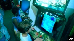 FILE- A July 21, 1987 photo shows Carlos Tunnerman, 10, playing the "Contra" video game at an arcade in a Miami, Fla. 