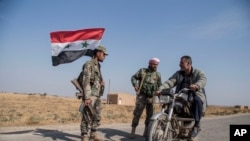 Syrian government forces man a checkpoint near the town of Tal Tamr, north Syria, Oct. 22, 2019. 
