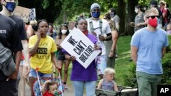 Katrina Hendricks, left, pushes a stroller holding her son, Melo, as her mother, Elaine Loving, walks alongside her at a Juneteenth rally and march through a historically Black neighborhood in Portland, Ore, June 19, 2020. 