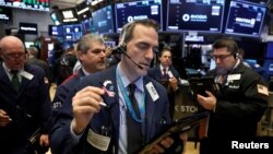 Traders work on the floor of the New York Stock Exchange shortly after the opening bell in New York, March 19, 2018. 