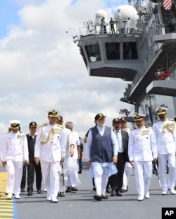 In this handout picture provided by the Press Information Bureau, Indian Prime Minister Narendra Modi inspects the INS Vikrant during its commissioning in Kochi, India, Sept. 2, 2022.