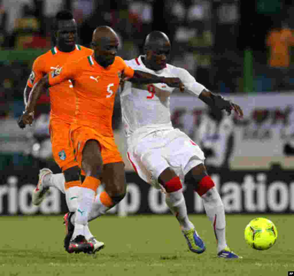 Didier of Ivory Coast fights for the ball with Moumouni of Burkina Faso during their African Nations Cup soccer match in Malabo