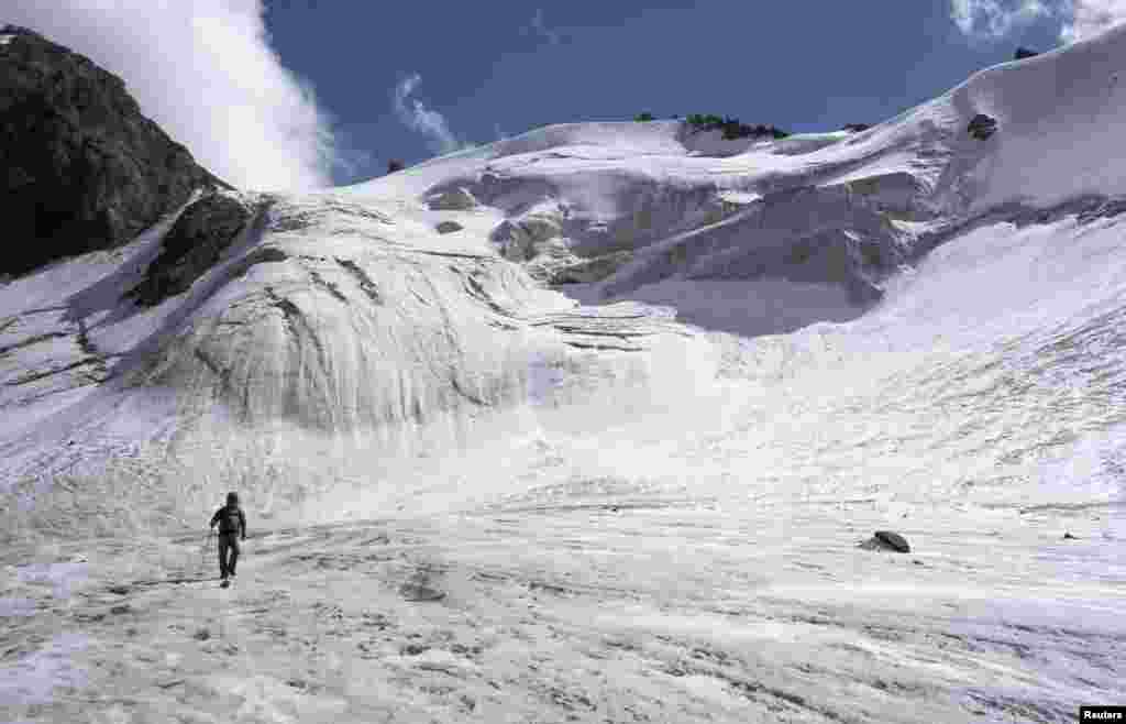 A tourist walks across the Manshuk Mametova glacier, about 3,550 meters (11,647 feet) above sea level, in the mountains of Tien Shan outside Almaty, Kazakhstan, Sept. 6, 2014.