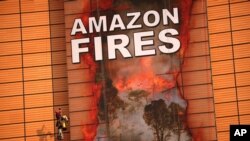 Climate activists place a giant banner covering the facade of the European Commission headquarters in Brussels, Belgium, Sept. 11, 2020. 