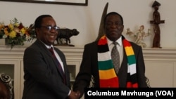 Dr. Bernard Madzima, left, the executive officer of the Zimbabwe National AIDS Council, is shown with President Emmerson Mnangagwa in September 2022. Madzima says the country enforces a policy of no discrimination against HIV patients.