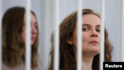 Katsiaryna Andreyeva and Darya Chultsova, Belarusian journalists, stand inside a defendants' cage during a court hearing in Minsk, Feb. 18, 2021.