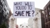 FILE - A anti-global warming protester holds up a sign in Cleveland, Ohio, near the Republican National Convention, July 18, 2016.