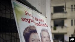 A campaign poster for Workers Party presidential candidate Dilma Rousseff, left, with Brazil's President Luiz Inacio Lula da Silva sits in the Andarai slum in Rio de Janeiro, Brazil, 01 Oct 2010