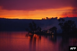 Embers glow against the smoke-filled sunset near Gumeracha in the Adelaide Hills, Jan. 3, 2015.