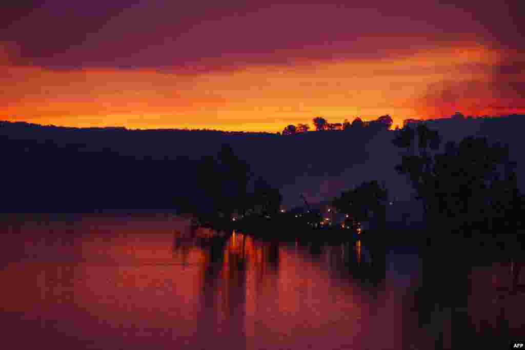 Embers glow against the smoke-filled sunset near Gumeracha in the Adelaide Hills, Australia, Jan. 3, 2015.