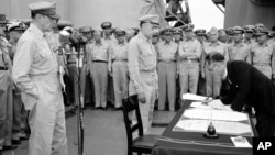 1945年9月2日日本外務大臣重光葵在停泊在東京灣的美國“密蘇里”號戰艦上簽署日本無條件投降的正式文件。左一是美國麥克阿瑟將軍，當中是理查德·薩瑟蘭中將。