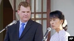 Nobel laureate Aung San Suu Kyi listens to Canadian Foreign Affairs Minister John Baird following a meeting at her home in Rangoon, Burma, March 8, 2012.