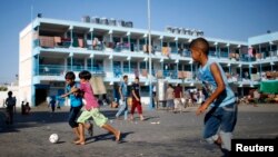 Bocah-bocah Palestina bermain bola di tempat penampungan mereka di sebuah sekolah milik PBB di Jabaliya, Jalur Gaza (31/7/2014). 