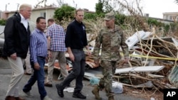FILE - President Donald Trump walks with FEMA administrator Brock Long, second from right, and Lt. Gen. Jeff Buchanan, right as he tours an area affected by Hurricane Maria in Guaynabo, Puerto Rico, Oct. 3, 2017. 