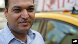 In this July 21, 2015 photo, yellow cab driver Jatinder Singh poses for a portrait near his taxi in New York. 