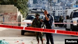 Pasukan keamanan Israel berdiri di dekat lokasi penusukan oleh seorang warga Palestina di Tal-Rumida, Hebron di wilayah Tepi Barat, 17 September 2016 (REUTERS/Mussa Qawasma)