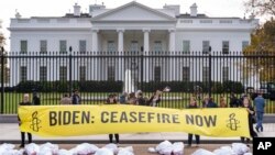 FILE — A large banner that says "Biden: Ceasefire Now," representing those killed in the escalating conflict in Gaza and Israel, is displayed in front of the White House, November 15, 2023, in Washington. 