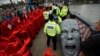 Environmental protesters gather around the head of a statue confiscated by police on Lambeth bridge in central London.