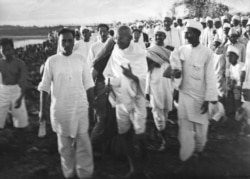 Mahatma Gandhi memberikan instruksi terakhir di pantai dekat Dandi, India, saat dia dan para pendukungnya bersiap-siap untuk berdemonstrasi di Salt Satyagraha (Salt March), 6 April 1930.(Foto AP / Foto Deutscher Dienst / W. Bossard)