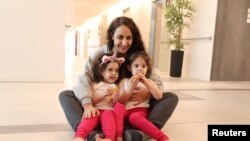 FILE - Sharon Aloni, 34, holds her 3-year-old twins, Yuli and Emma, who were taken hostage during the October 7 attack by Hamas, at Schneider Children's Medical Center in Petah Tikva, Israel, on Nov. 27, 2023. (Schneider Children's Medical Center via Reuters)