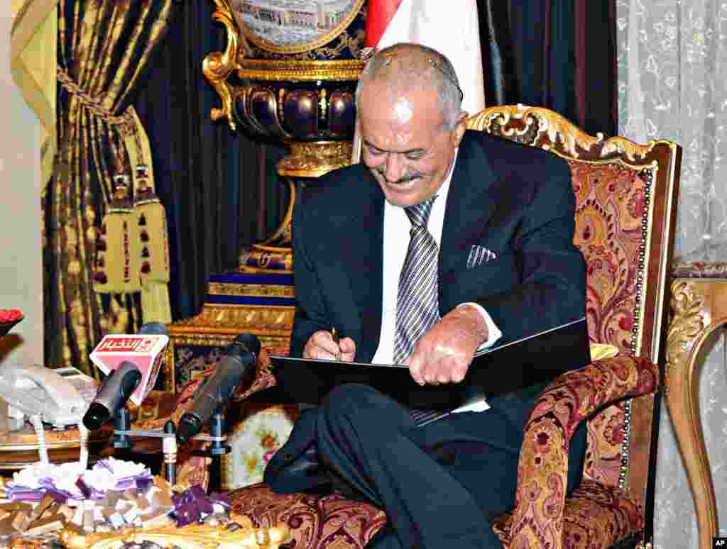 November 23, 2011: Photo released by Saudi Press Agency shows Yemeni President Ali Abdullah Saleh signing an agreement to step down, Riyadh, Saudi Arabia.