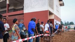 Les électeurs attendent pour voter devant un bureau de vote à Monrovia, le 8 décembre 2020