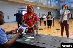Seorang warga mendaftar ulang untuk memberikan suara dalam pemilihan paruh waktu dan pemilihan di seluruh negara bagian di Lucky Shoals Park, Norcross, Georgia, A.S. 8 November 2022. (REUTERS/Jonathan Ernst)
