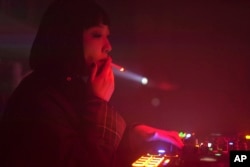 FILE - A DJ who goes by the signifier    sanction  Kuro smokes a cigaret  arsenic  she plays euphony  successful  Changchun successful  northeastern China's Jilin state  connected  Oct. 12, 2024.