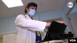 Carlos Riveros, médico internista del hospital de Coral Gables (Florida), revisa en su consulta algunos casos de pacientes con coronavirus. [Foto: Antoni Belchi / VOA]. 