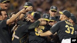 Jugadores de los Atléticos de Oakland celebran luego de conseguirse un comodín en la Liga Americana, al ganar a los Rangers de Texas, el lunes 1 de octubre de 2012.