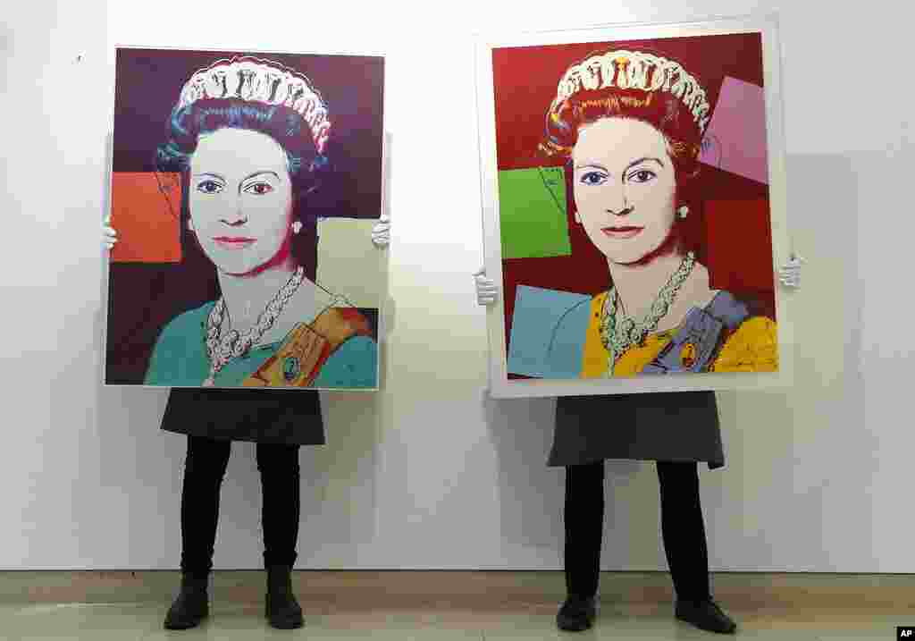 Gallery technicians display screenprints of Queen Elizabeth II by Andy Warhol, at Christie&#39;s auction rooms in London. The screenprints will be on sale online until March 31.