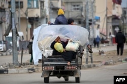 Orang-orang mengangkut barang-barang mereka saat berkendara melalui kamp pengungsi Bureij di Jalur Gaza bagian tengah menuju kawasan di bagian utara yang dikuasai Palestina, 7 Februari 2025. (Eyad BABA / AFP)