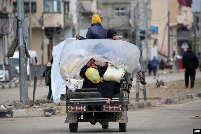 Orang-orang mengangkut barang-barang mereka saat berkendara melalui kamp pengungsi Bureij di Jalur Gaza bagian tengah menuju kawasan di bagian utara yang dikuasai Palestina, 7 Februari 2025. (Eyad BABA / AFP)