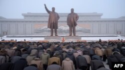 Pyongyang residents bow before the statues of late North Korean leaders Kim Il Sung and Kim Jong Il during National Memorial Day on Mansu Hill in Pyongyang on Dec, 17, 2018. 