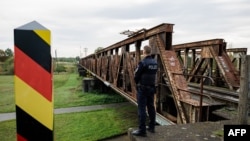 Službenik njemačke savezne policije stoji uz često korištenu rutu migranata preko njemačko-poljske granice u blizini Forsta, u istočnoj Njemačkoj, 11. oktobra 2023.