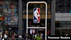 El logotipo de la NBA se muestra cuando las personas pasan por la tienda de la NBA, en Nueva York.