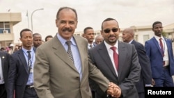 FILE - Eritrean President Isaias Afwerki and Ethiopia's Prime Minister Abiy Ahmed walk together at Asmara International Airport, Eritrea July 9, 2018.