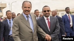 FILE - Eritrean President Isaias Afwerki and Ethiopia's Prime Minister Abiy Ahmed walk together at Asmara International Airport, Eritrea, July 9, 2018.