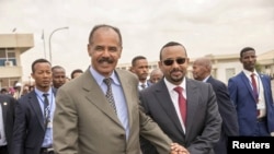 FILE - Eritrean President Isaias Afwerki, left, and Ethiopian Prime Minister Abiy Ahmed walk together at Asmara International Airport, Eritrea, July 9, 2018.
